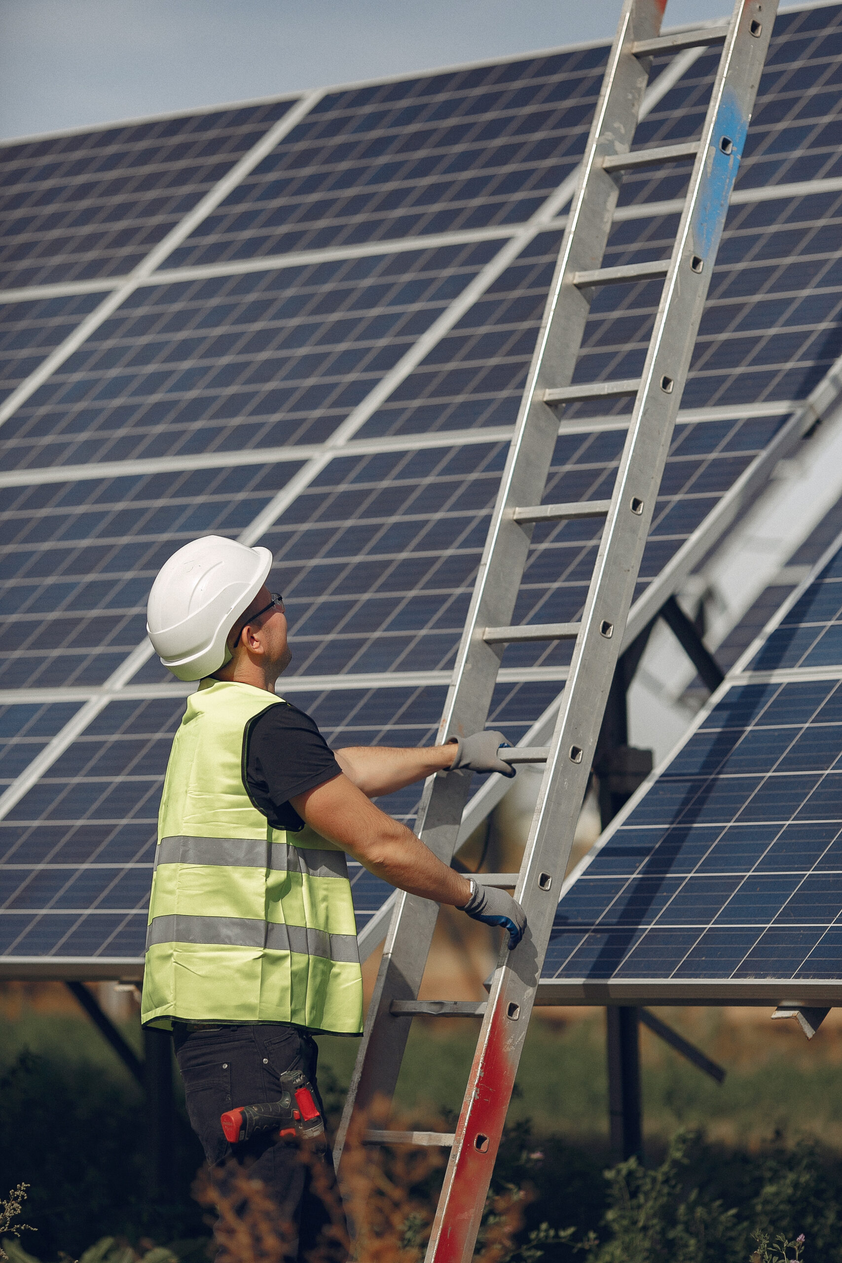 Man in a white helmet near a solar panel
